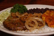 Bistec Palomilla ~ mojo marinated pan seared sirloin steak covered with caramelized onions served with arroz blanco, frijoles negros and platanos maduros